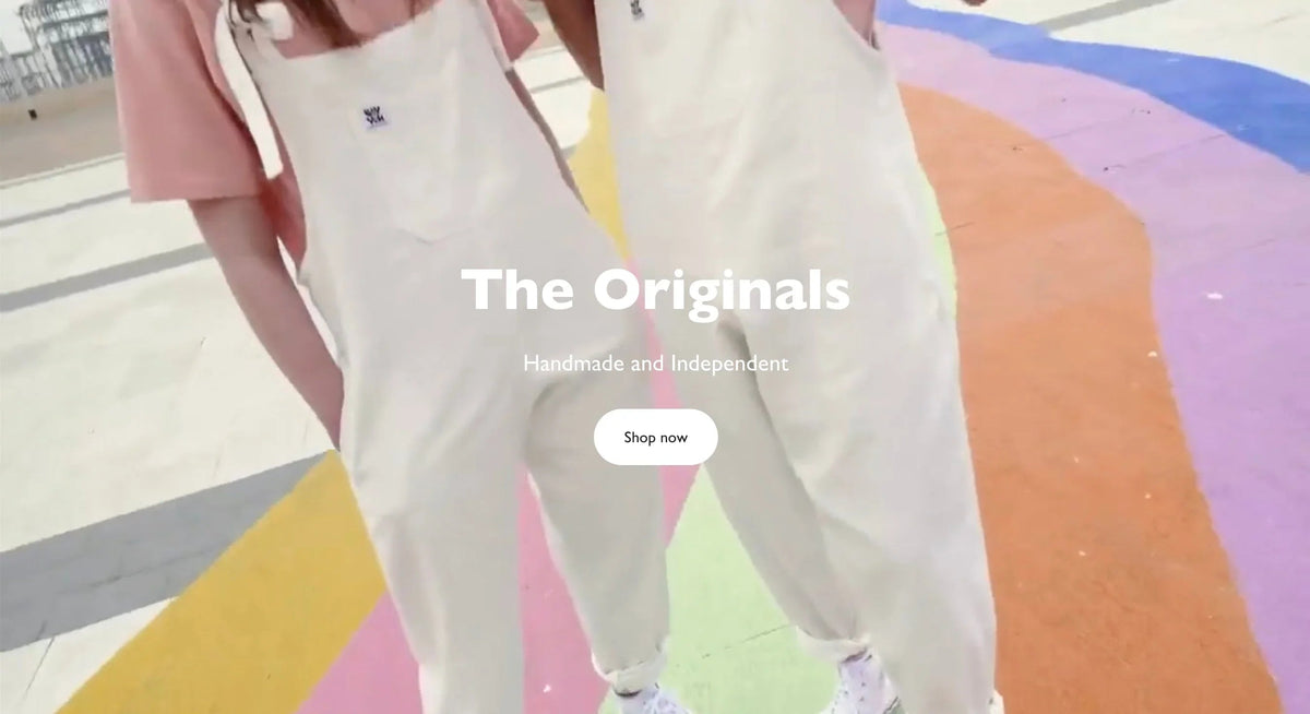 White overalls with pink shirt on colorful pavement, handmade and independent fashion